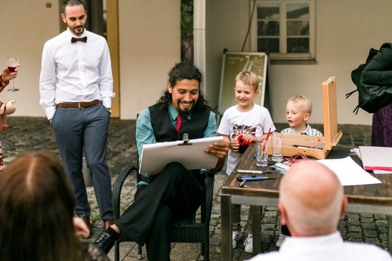 Ein Maler zeichnet die Gäste auf einer Hochzeit